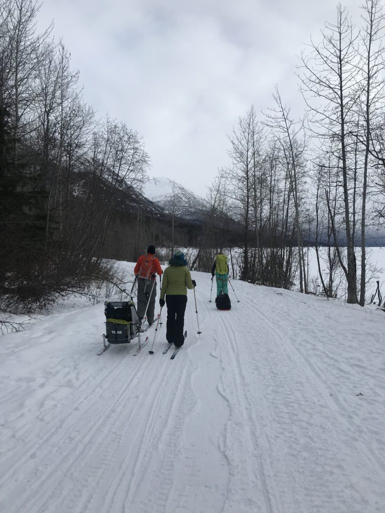 Skiers drag sleds along Eklutna Lake, Alaska.