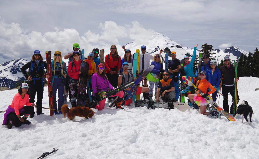 A large group dressed in costumes and ski gear celebrates a wedding with a Newlywed Shred!