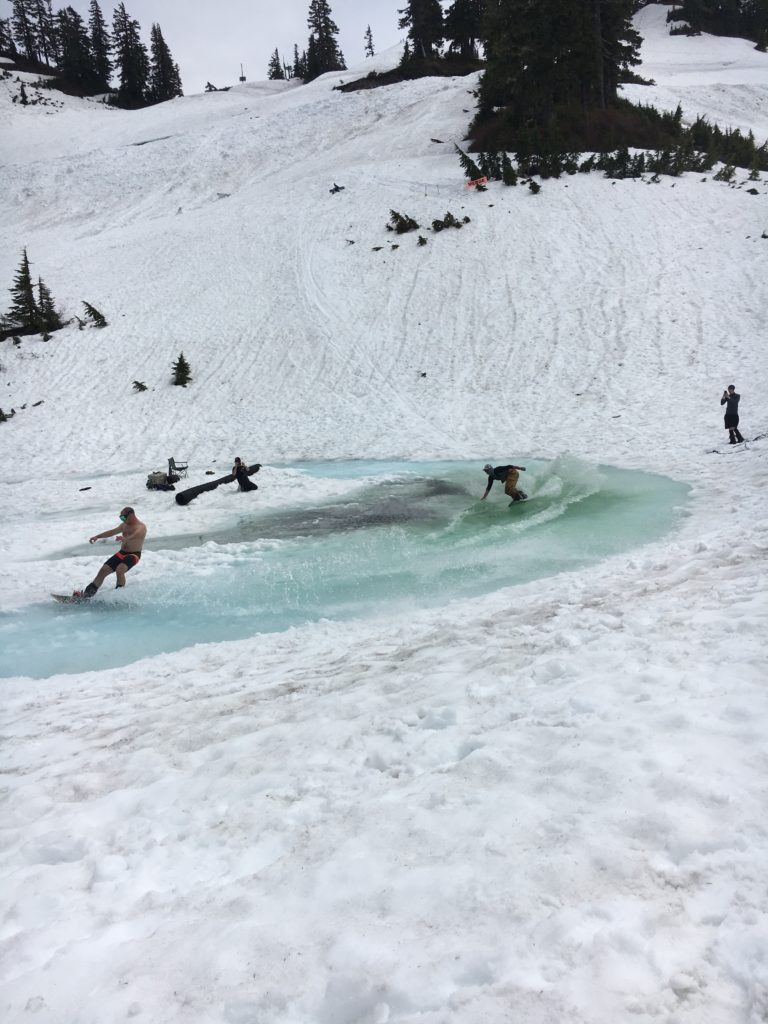 Snowboarders pond skimming at Mt. Baker.