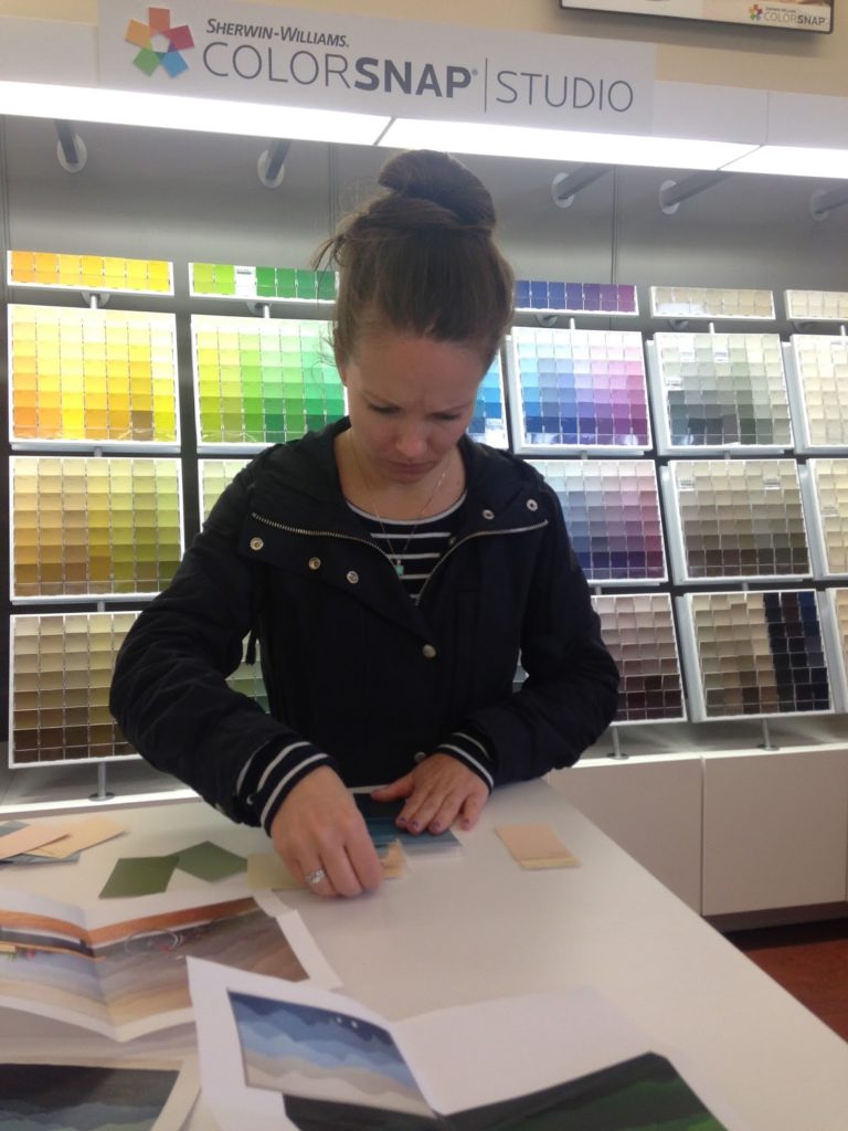A woman looks at paint samples to select the best color combo.